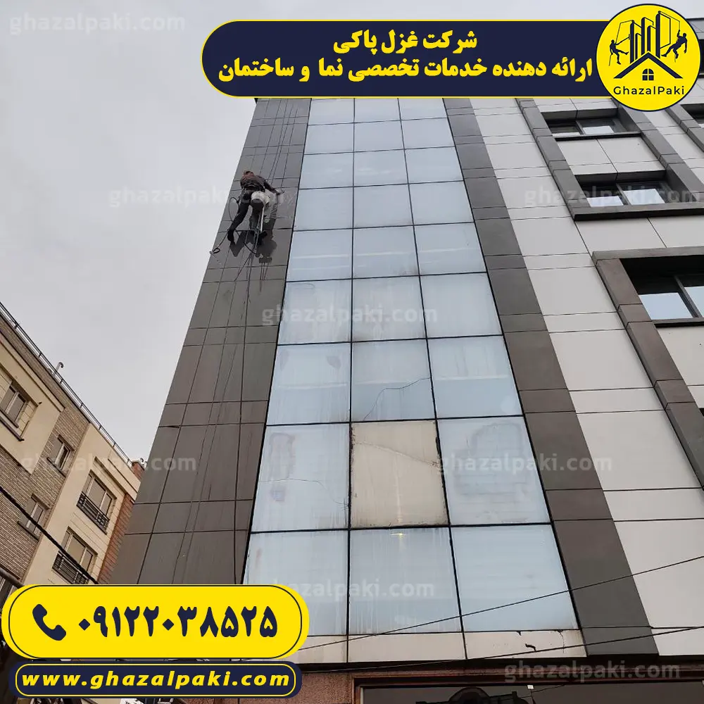 تکنسین کار در ارتفاع شرکت غزل پاکی در حال تمیز کردن شیشه نمای ساختمان با طناب در تهران